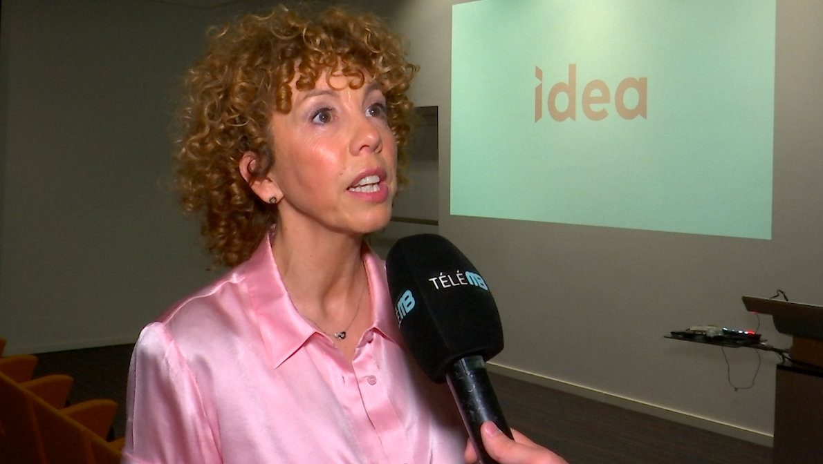 Photo de Caroline Descamps, la directrice d'IDEA au micro de Télé MB. Elle parle de la nouvelle identité pour IDEA et des futurs projets. Elle pose devant la nouvelle identité pour IDEA